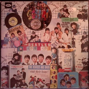 A wall covered with beatles memorabilia and pictures.