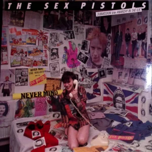 A woman sitting on top of a bed covered in posters.