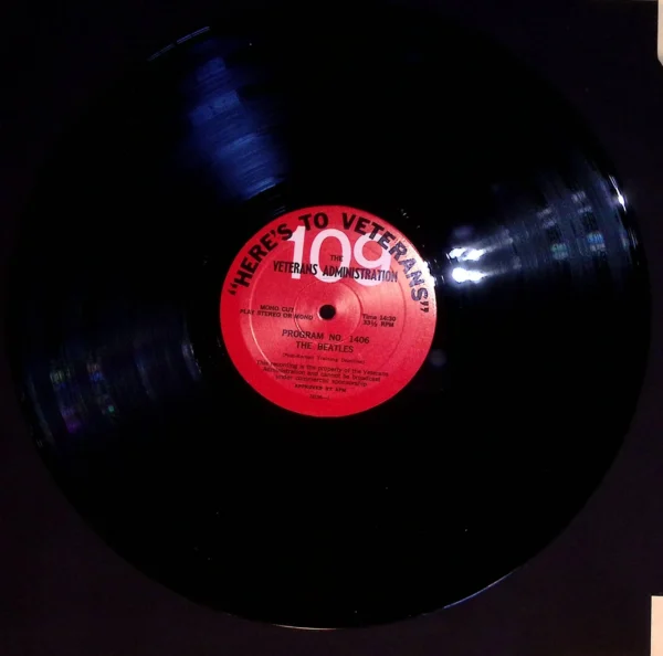 A black record with red label on it.