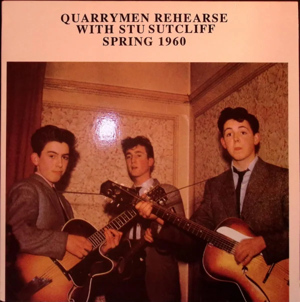 A group of men holding guitars in front of a wall.