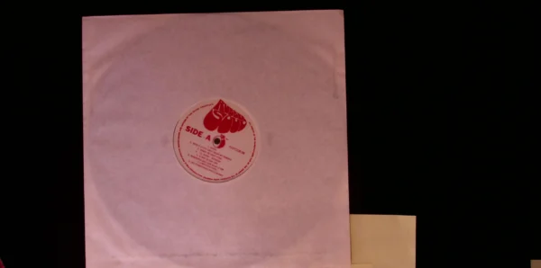 A pink paper with a red sticker on it