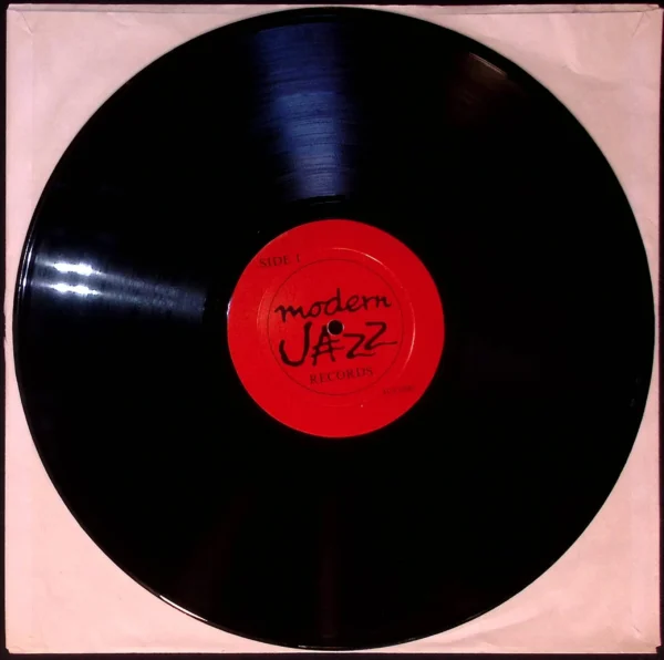 A black record with red label and the word " jazz ".