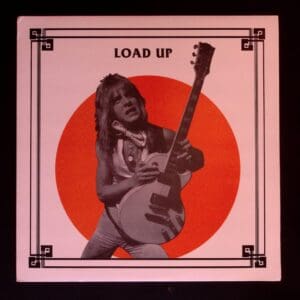 Here's an alt tag for the image: `Load Up album cover: Guitarist on red circle`