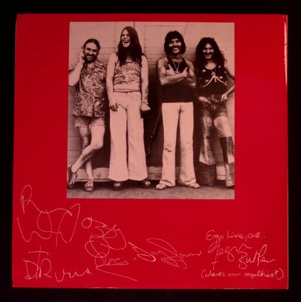 Band photo with autographs on red background.