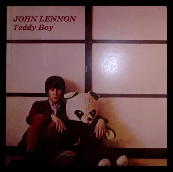 A man sitting next to a panda bear.