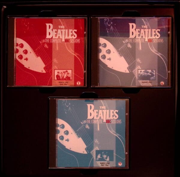 Three beatles cds are shown in a row.