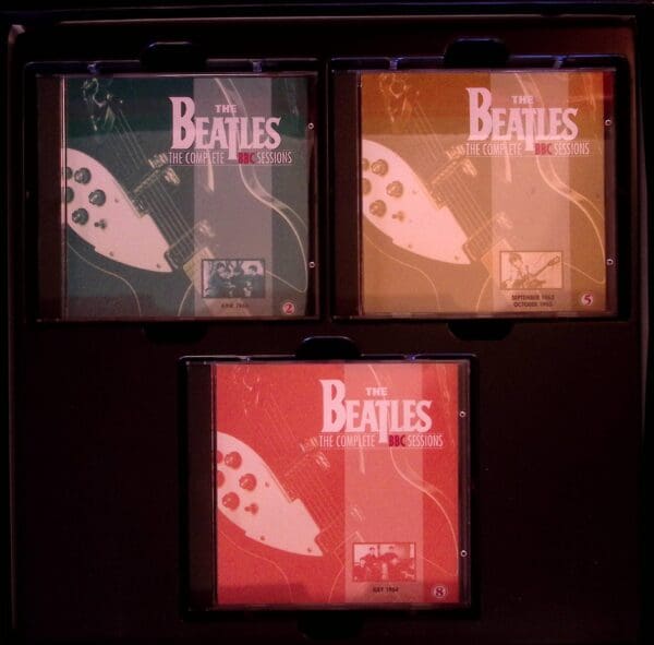 Three beatles cds are shown in a row.