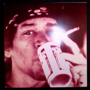 Here's an alt tag for the image: Man smoking and drinking from a cup.