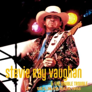 Stevie Ray Vaughan performing live with his guitar on stage.